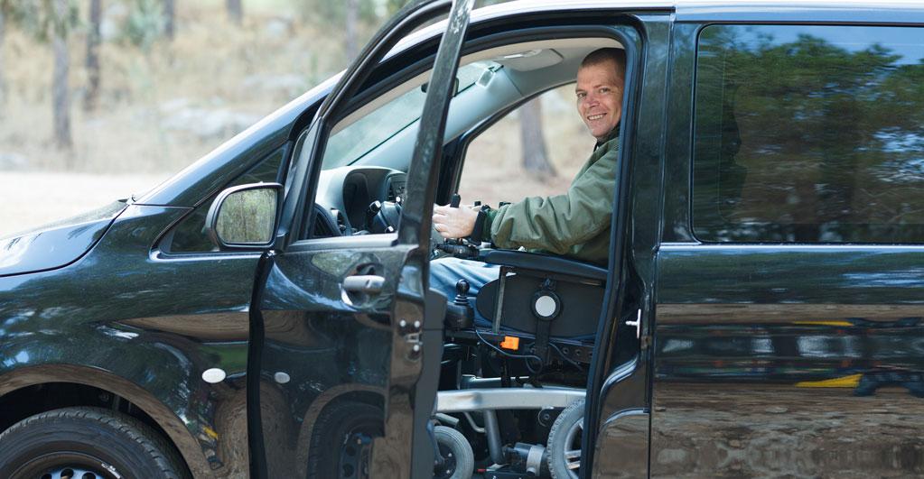 man in wheel chair driving car