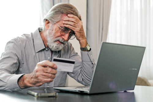 Man stressed out holding a credit card