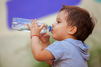 Little boy drinking bottle of water