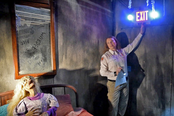 Inspector pointing out Exit sign in haunted house