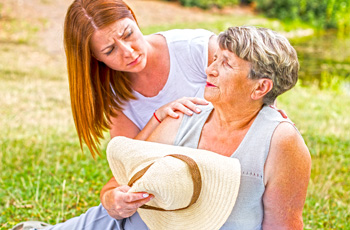 Woman tending to overheated older woman
