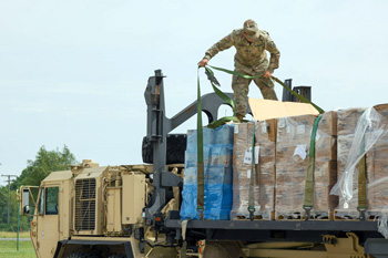 Soldier unwrapping pallet of boxes