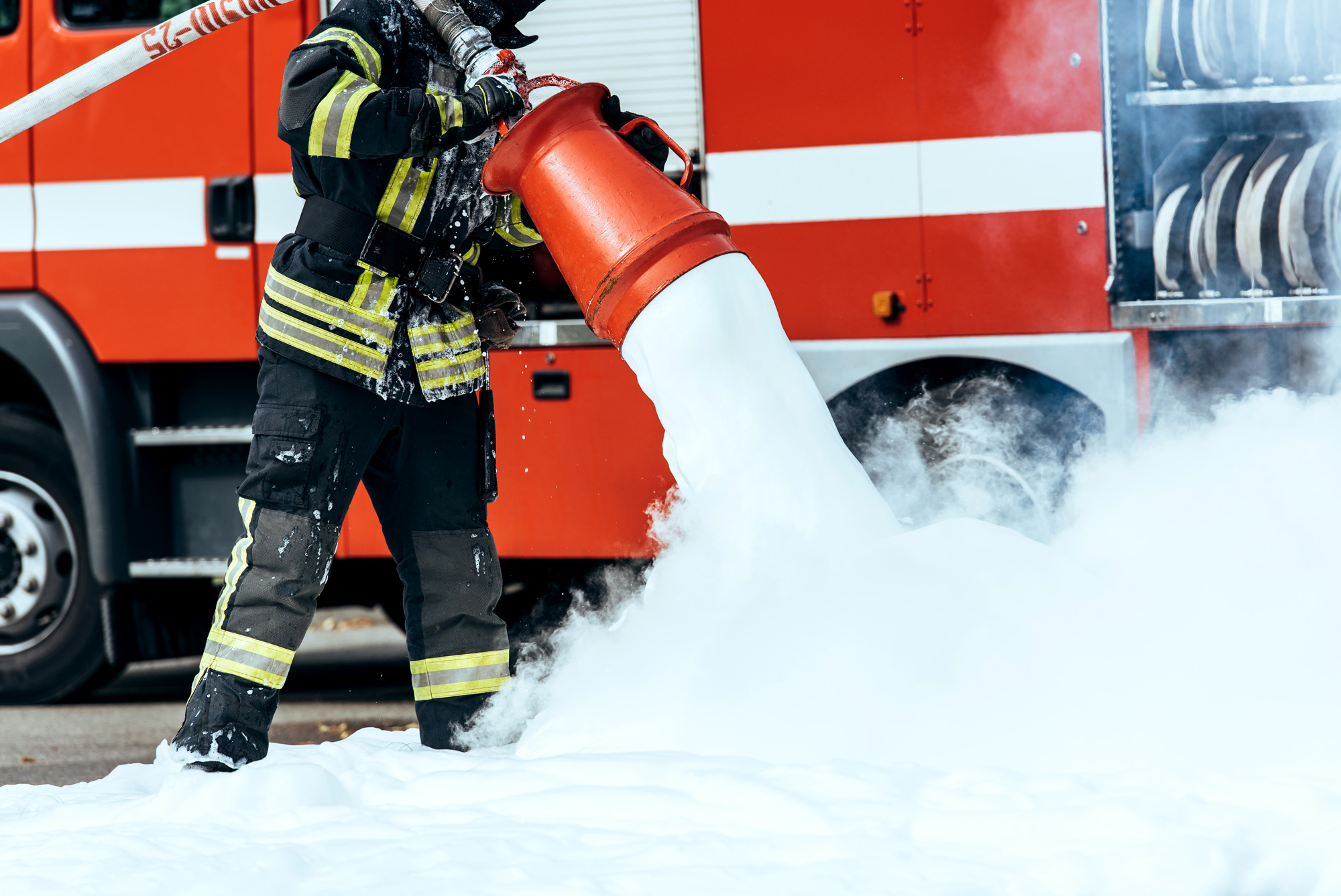 Firefighter pouring foam