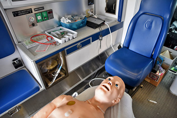 Human patient simulator on table inside ambulance