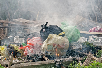 Pile of bags of trash burning