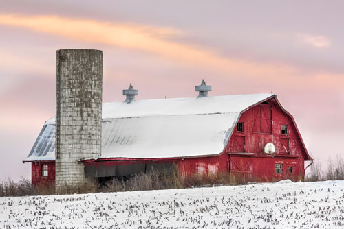 Snow on field and red barn