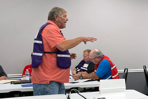 Man gives lecture to room of exercise participants