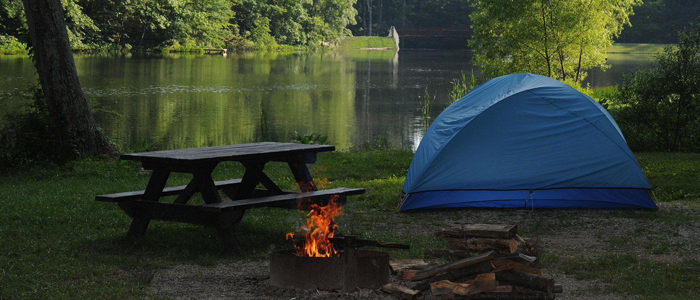 fireplace and a tent by a lake