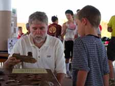 Former State Archaeologist Dr. Rick Jones sharing information about archaeology with a young person.