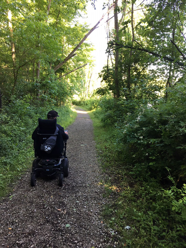 Man using trail chair on trail.