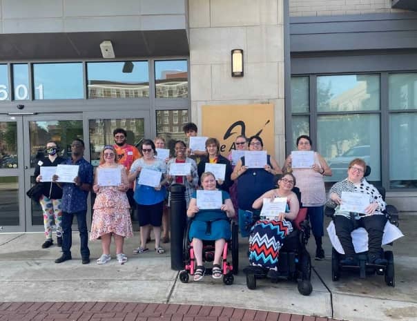 Group photo of people in front of a building.