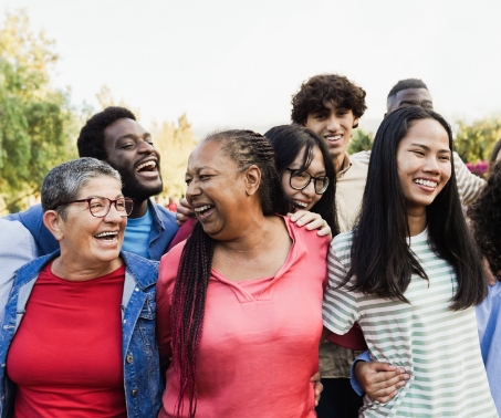 Group of people smiling and laughing outdoors.