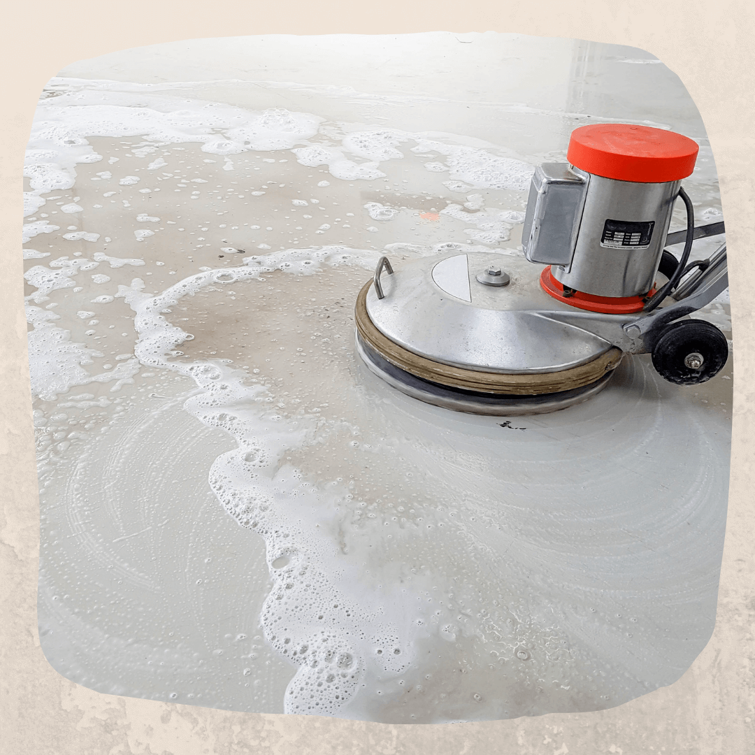 Image of a concrete floor being scrubbed with an electric floor scrubber