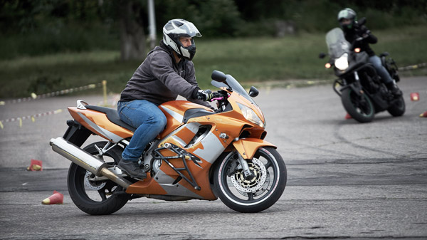 Two motorcyclists riding sport bikes through a course.
