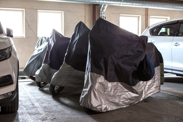 Motorcycles covered in a garage.