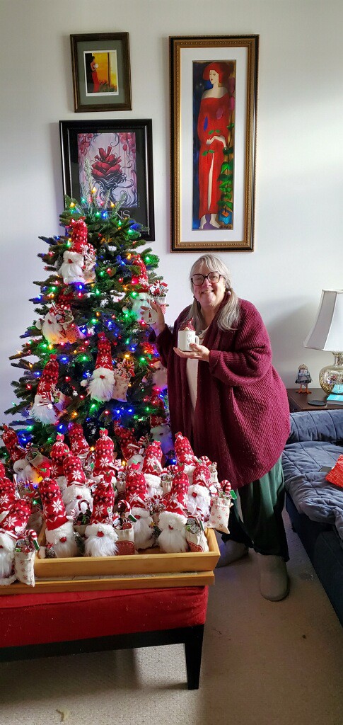 WIC Employee Deb Bovard poses with gnome ornaments in front of Christmas tree